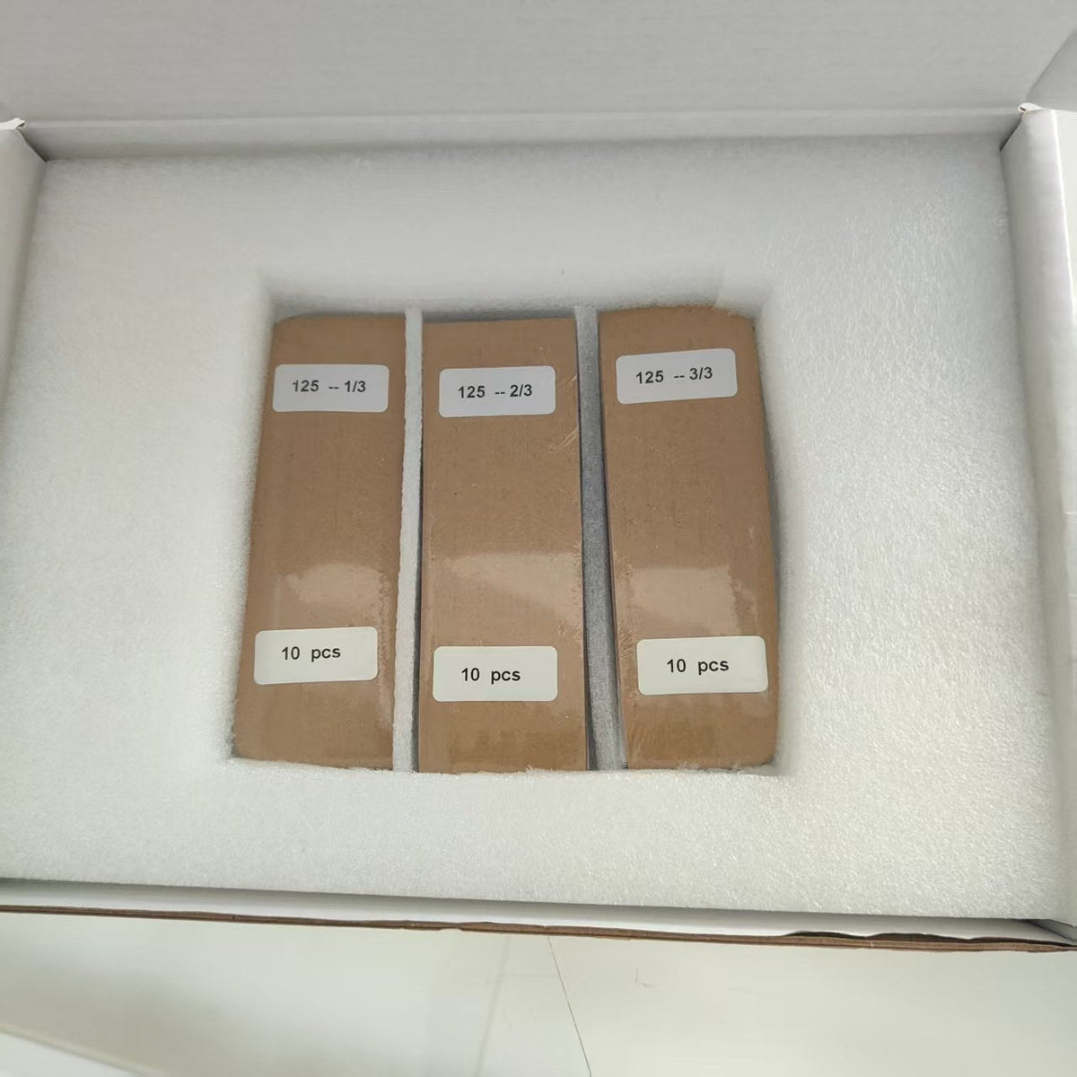 One-third-cut 125 mm back-contact solar cells packed as three separate bundles labelled 125 -- 1/3, 2/3 and 3/3, each 10 pcs, in a foam-lined carton