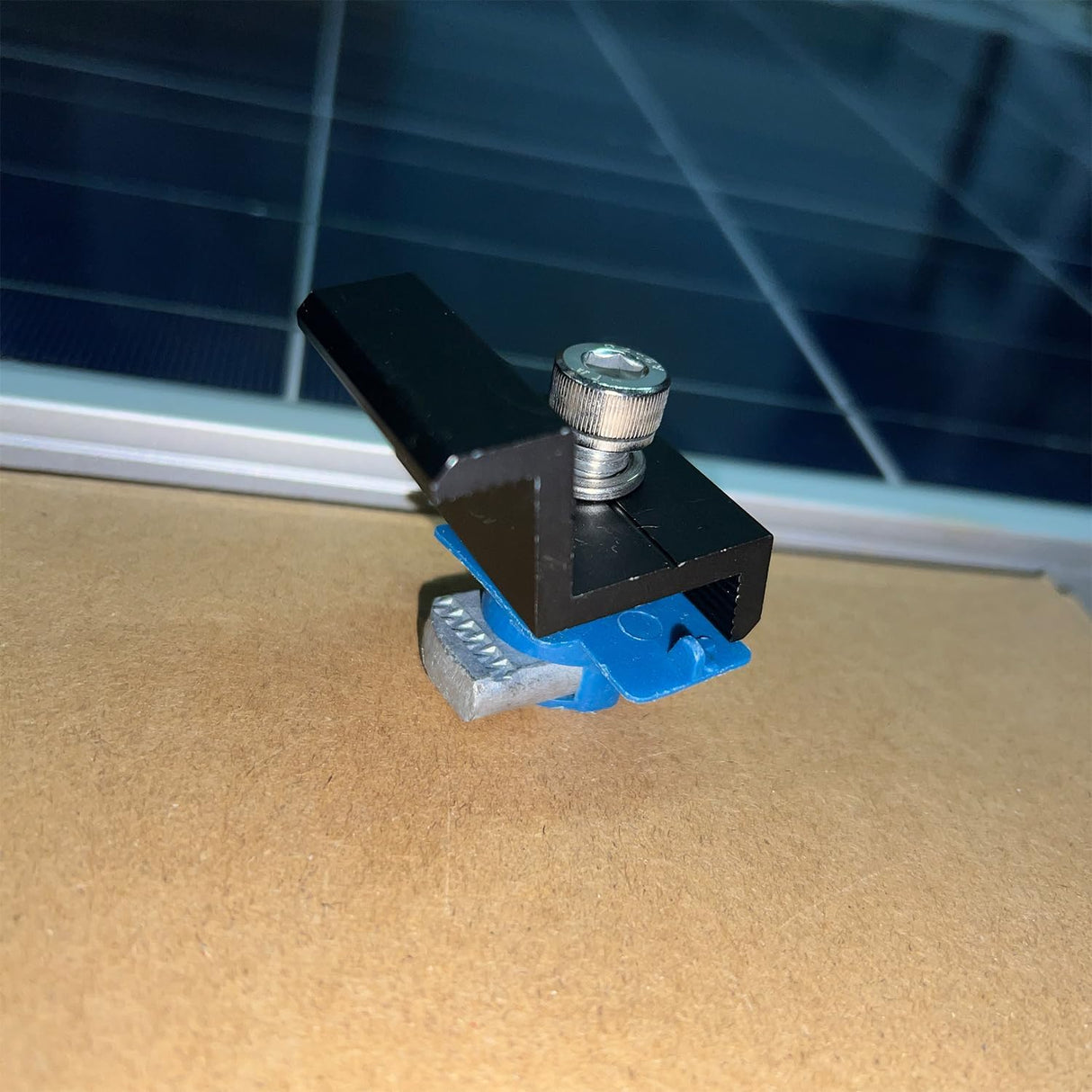 Black Unistrut end clamps securing a solar panel frame