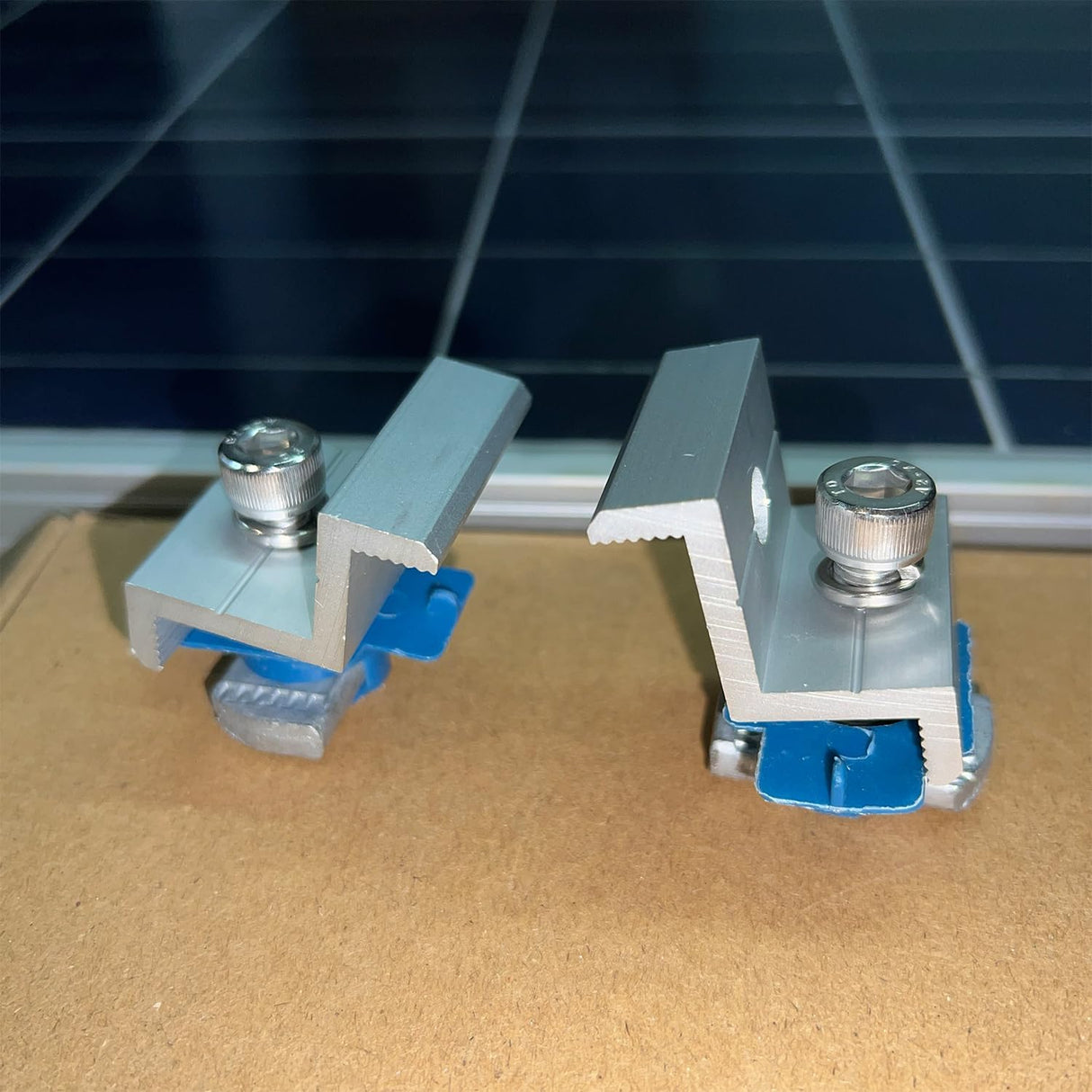 Silver solar panel end clamp secured to a framed module