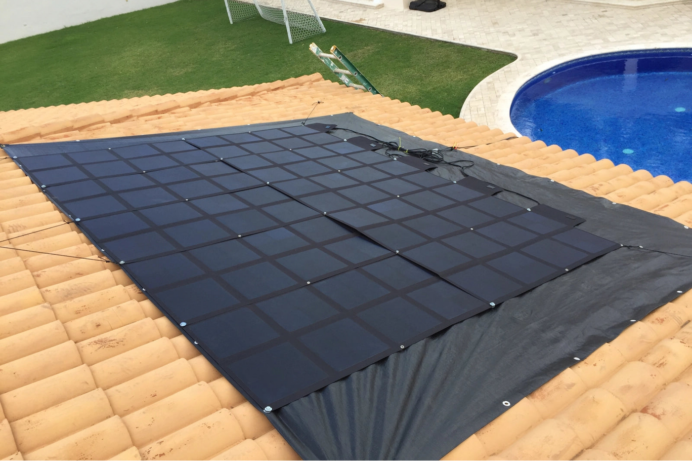 large solar blanket system secured on tiled roof for residential off grid power