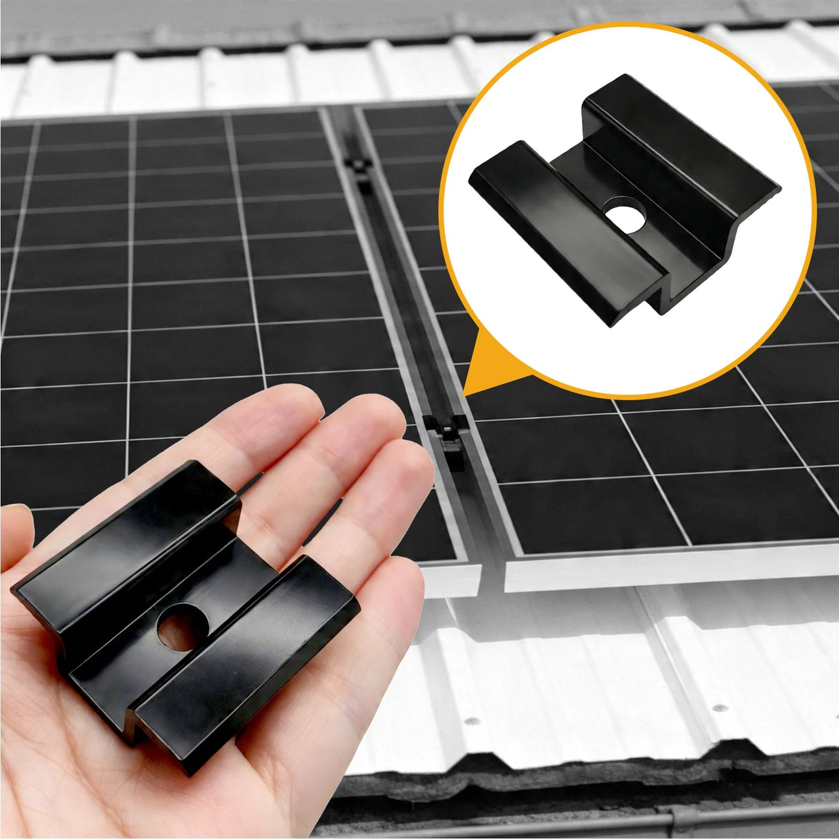 Black solar panel mid clamp held beside a rail-mounted framed PV array