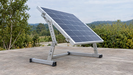 A solar module propped on a low inspection stand by tilt brackets with hinges and locking holes, focused on the adjustment and lock points.