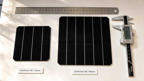 Flat lay of SunPower IBC solar cells in 125mm and 166mm sizes with precision measurement tools on white workbench