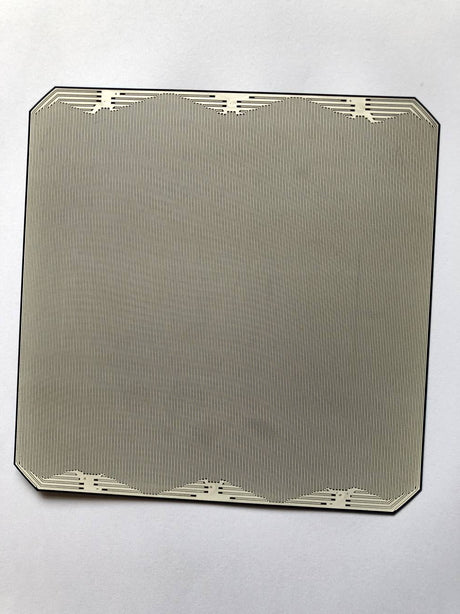 Rear side of a full-size back-contact solar cell with interdigitated contact fingers and clipped corners on a white background
