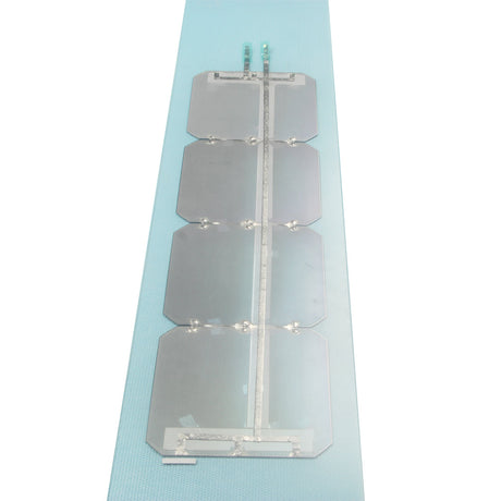 Interconnected solar cell string on light blue backing strip