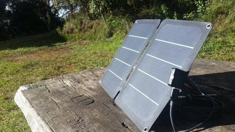 User-supplied photograph: two-section compact solar charger on an outdoor wooden surface