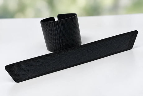 AI-edited user photograph: one textured flexible strip rolled and a second strip laid flat