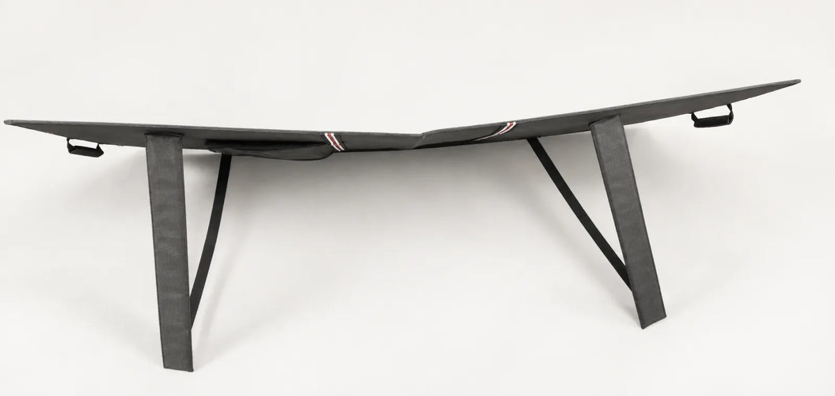 Rear of a folding solar panel showing two fabric support legs with black retaining straps