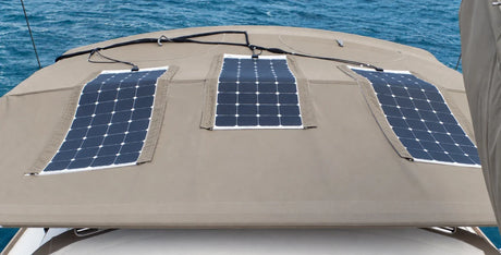 AI-retouched user photograph: three flexible solar panels arranged on a curved canvas bimini with fabric edge strips