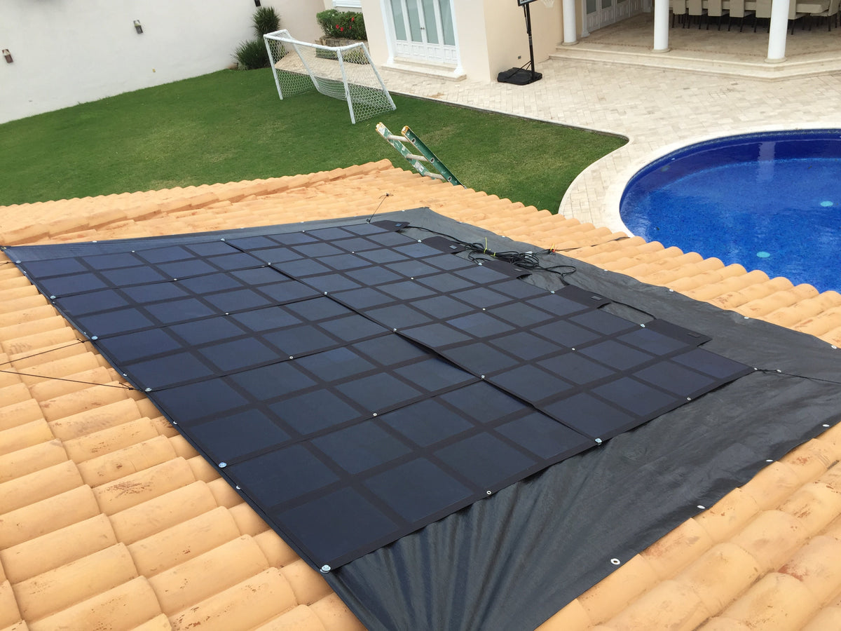 Large unfolded portable solar panels laid out on a terracotta tile roof