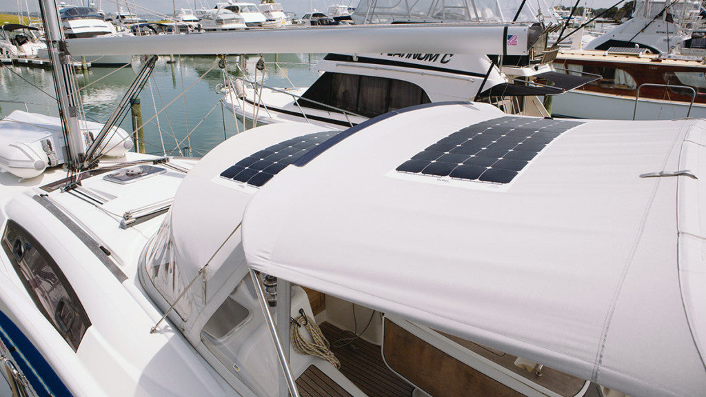 Flexible solar panels mounted on the white canvas bimini top of a sailboat