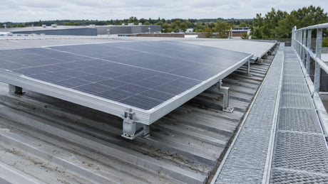 Ordinary industrial roof in clear daylight, one finished framed PV module securely mounted with visible air gap beneath it and safe maintenance walkway, no thermometer or heat-output claim.