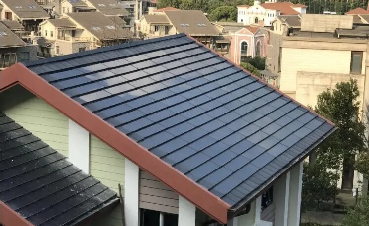 Installation example of dark solar roof tiles on a gable roof among neighbouring buildings