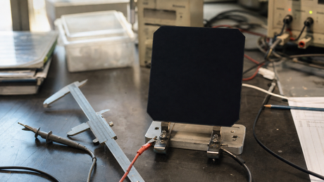IBC back-contact solar cell on a lab bench with no front busbars and interdigitated rear contacts