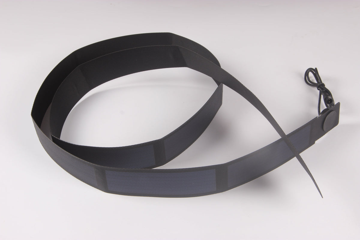 Long thin-film solar strip looped into a coil, showing how a deposited film laminate bends further than crystalline cells