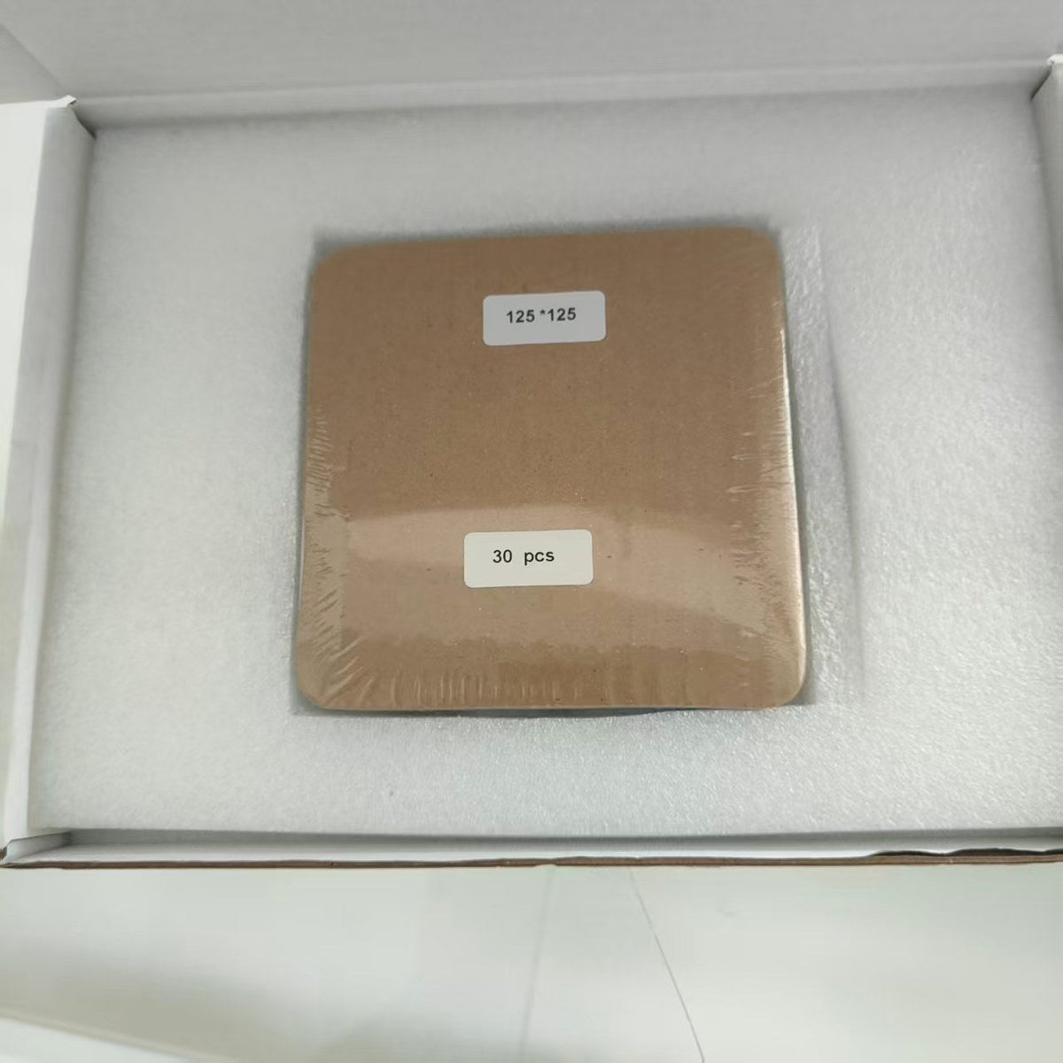 Shipping pack of full 125 mm back-contact solar cells: one shrink-wrapped bundle labelled 125*125 and 30 pcs, seated in a foam-lined white carton