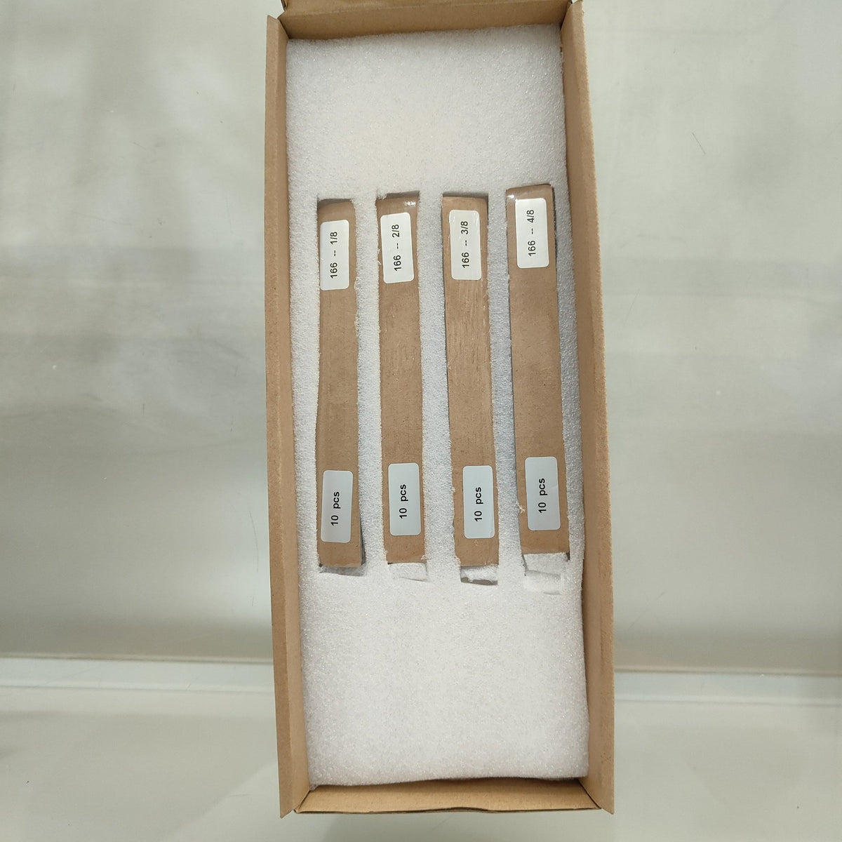 One-eighth-cut 166 mm solar cell strips 1/8 to 4/8 seated in individually cut foam slots so the bundles cannot press against each other in transit