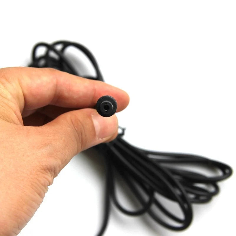 DC5521 plug tip held beside the coiled solar panel cable