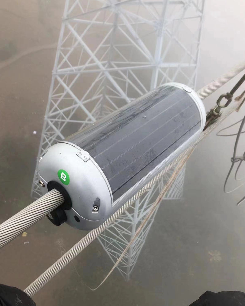 Cylindrical, solar-powered monitoring device clamped to a power line conductor