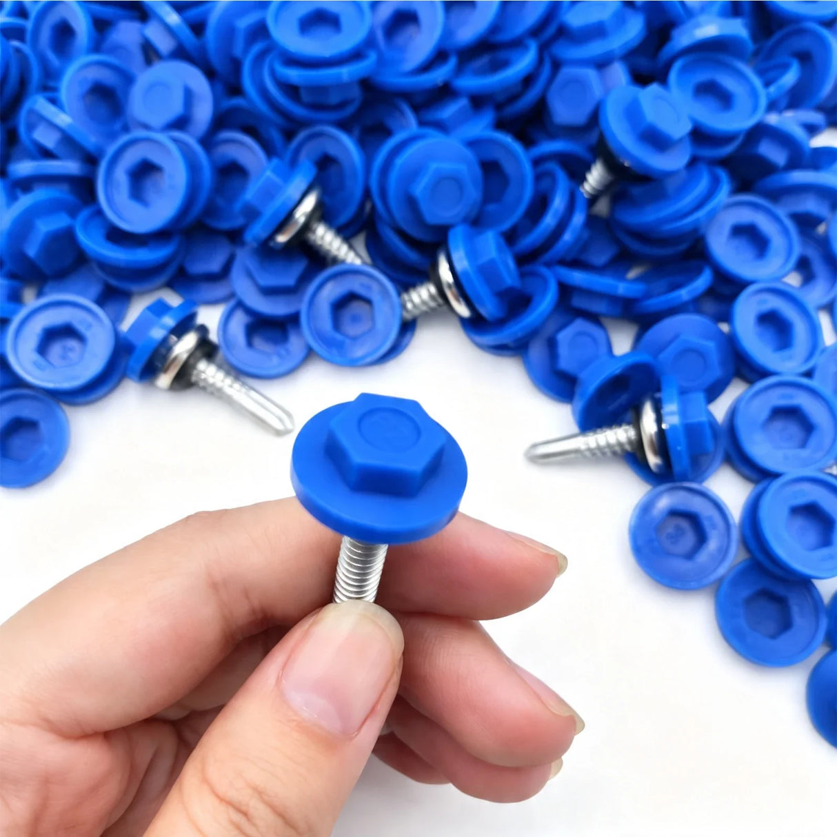 Blue plastic hex head cap fitted over a self-drilling screw head