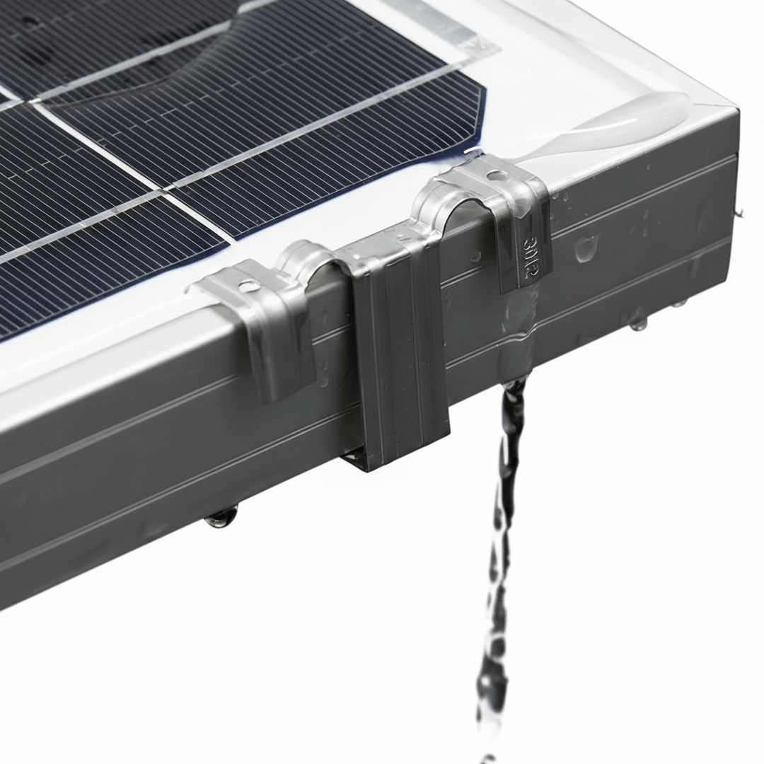 Stainless water drain clip mounted on a framed solar panel with water flowing through.