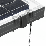 Stainless water drain clip mounted on a framed solar panel with water flowing through.