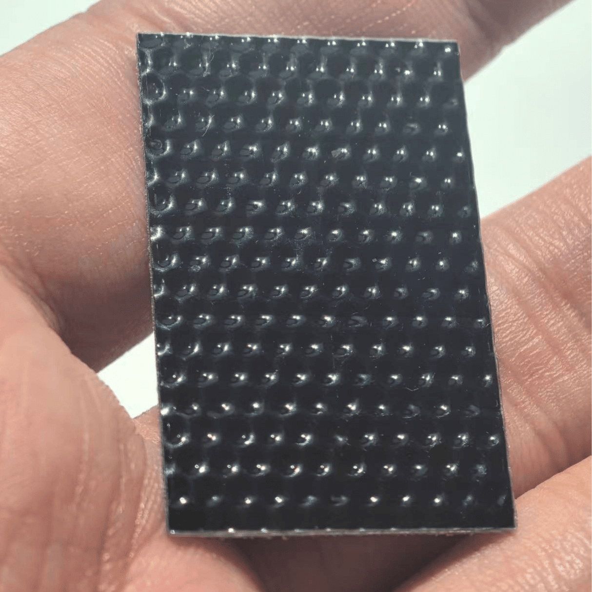 Close-up of the 35×22 mm mini panel held in hand, showing ETFE lens texture.