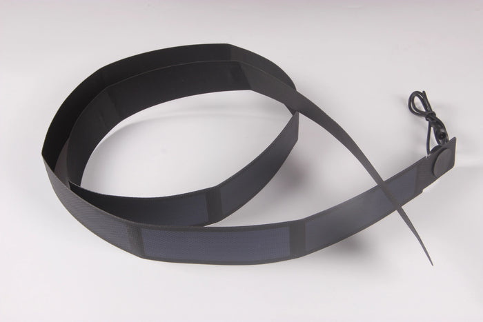 A long, flexible, black solar panel strip, possibly for a belt or strap, coiled on a white background with a connector at one end.