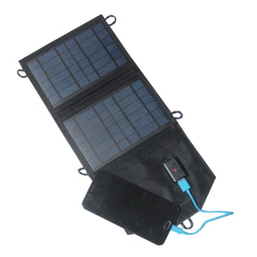 Black two-panel folding solar charger opened beside a phone