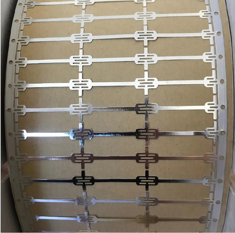Repeated dog bone solar cell connectors on a carrier strip