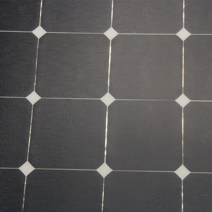 A close-up, top-down view of a monocrystalline solar panel, showing the detailed grid of dark, textured cells and white connectors.