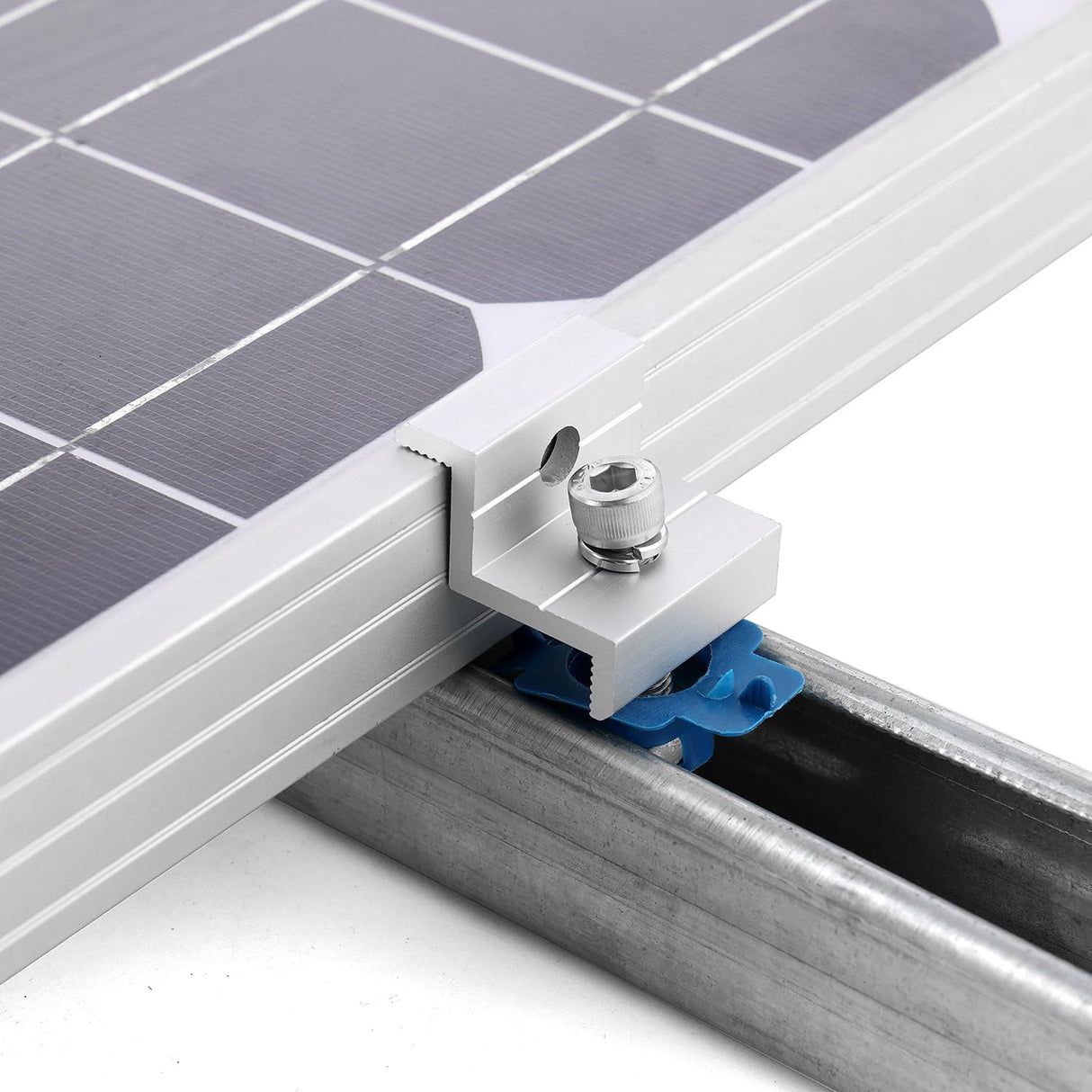 Silver solar panel end clamp securing a framed module to strut channel