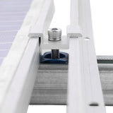 Silver solar panel mid clamp securing two framed modules to strut channel