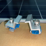 Silver solar panel end clamp secured to a framed module