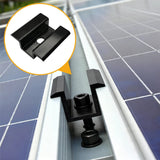 Close-up of a black solar panel mid clamp installed between two module frames