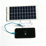 Solar panel charging a phone; phone not included