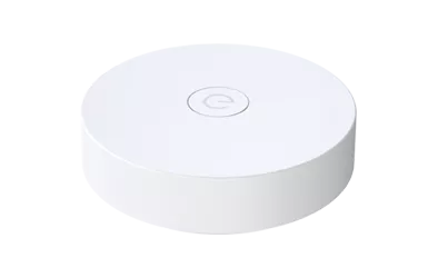White round wireless gateway puck with a central ring symbol, top view.